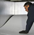 contractor installing TerraBlock™ floor insulation in a Deer Park crawl space