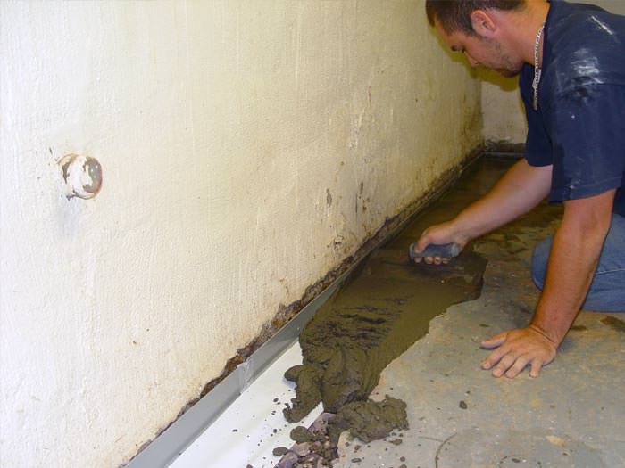 A basement waterproofer installing a perimeter drain system in Liberty Lake